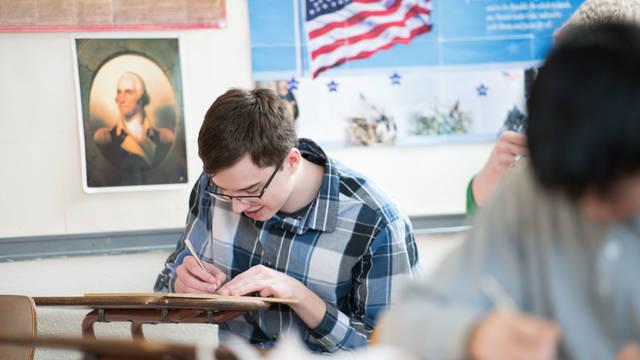 Student writes in classroom.
