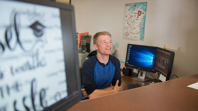 Male student working at a front desk at UW-Barron County