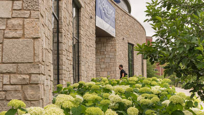 Student entering Davies Center Hydrangeas in full bloom