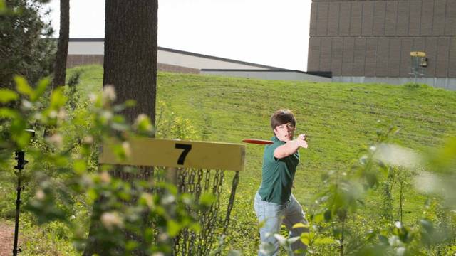 Student playing disc golf