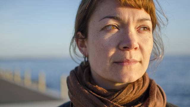 Woman staring off camera with ocean in the background