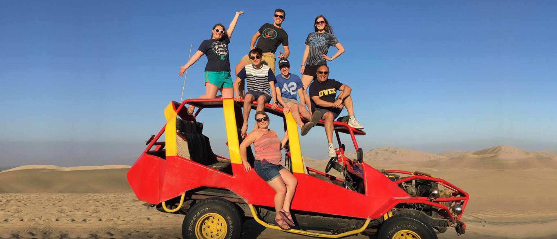 Educaiton students atop a dune buggy in Peru