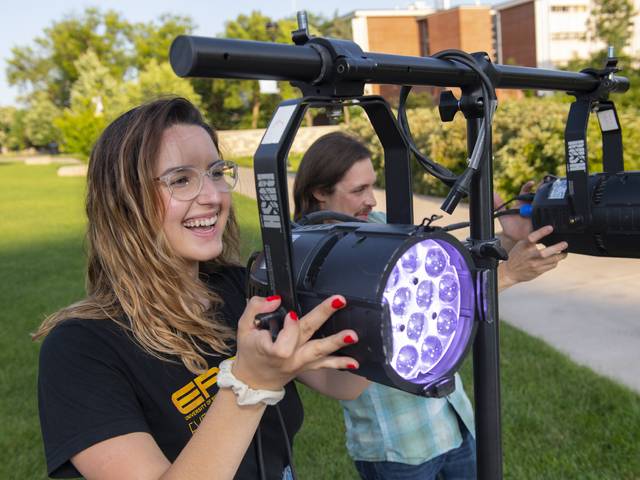 Maria Derrider operating stage lighting for campus mall concert