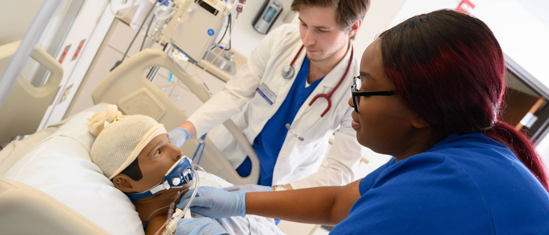 College of nursing students training on a manikin