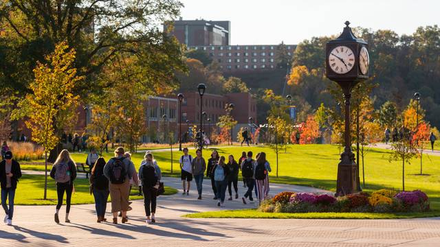 Students by clock tower in fall