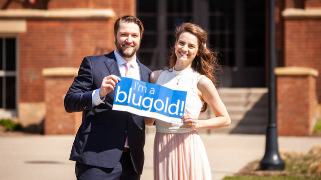 Ryan Moertel, '12 and Jena Weiler, '13 holding up an "I'm a Blugold" sign after their campus wedding ceremony