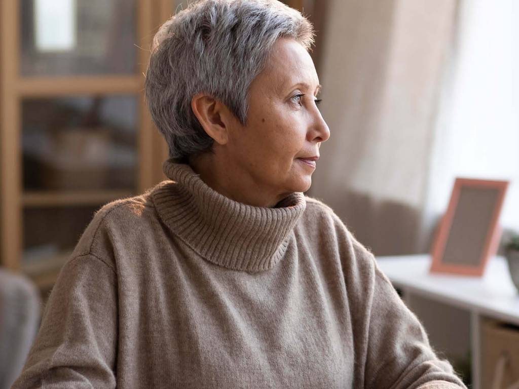An elderly woman looking out of the window