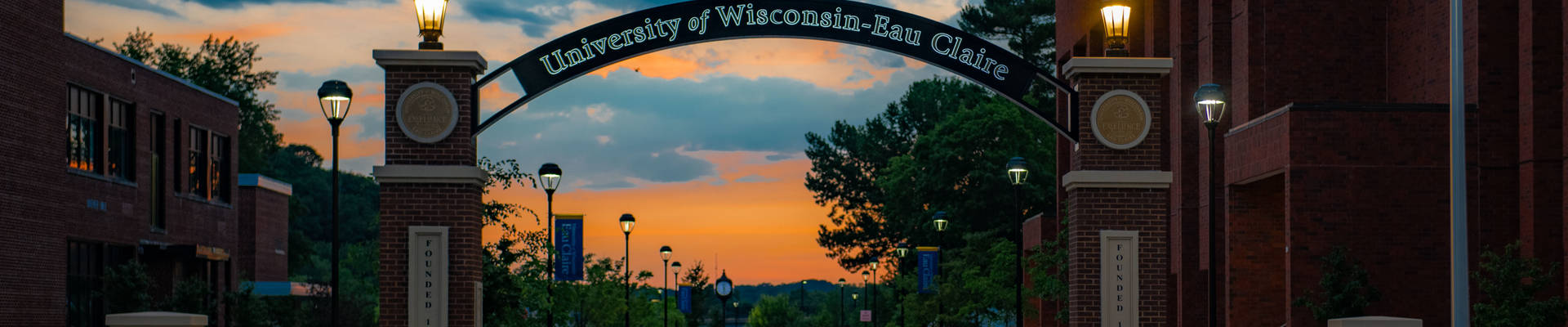 An evening picture of the UW-Eau Claire entrance gate with arch.