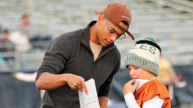 As a volunteer youth football coach, Terrell Kopping has helped Mason Bruesewitz (right) gain skills and fall in love with the sport.