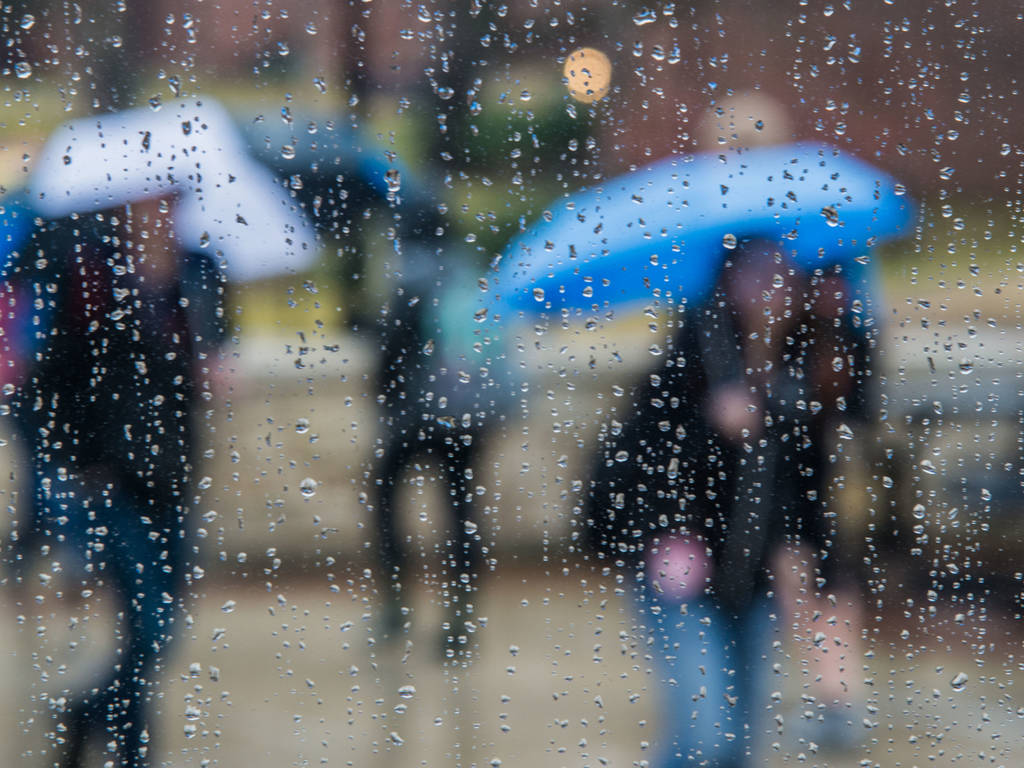 blurry image of people visible through a rainy window