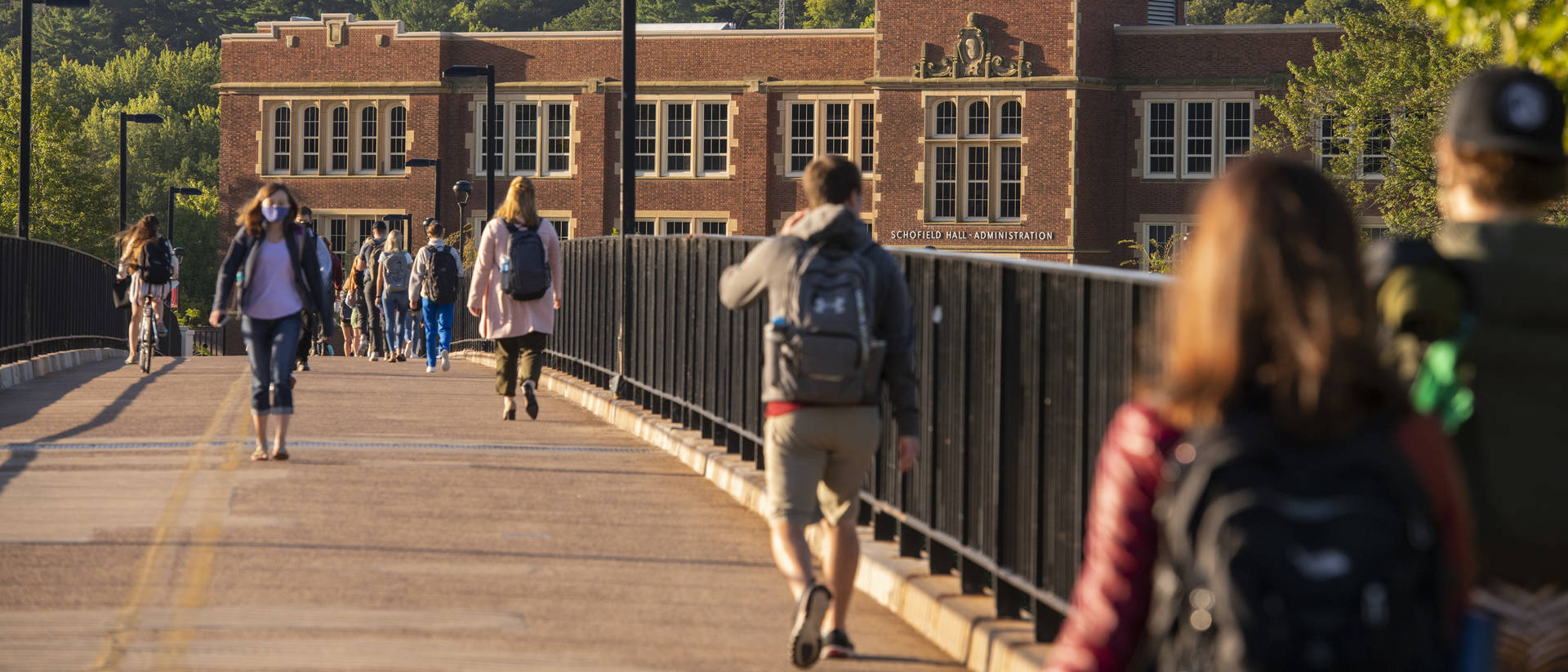 Students walk across footbridge in masks during first day of fall 2020 semester.
