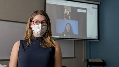 Female students in lab, one masked two on remote screen