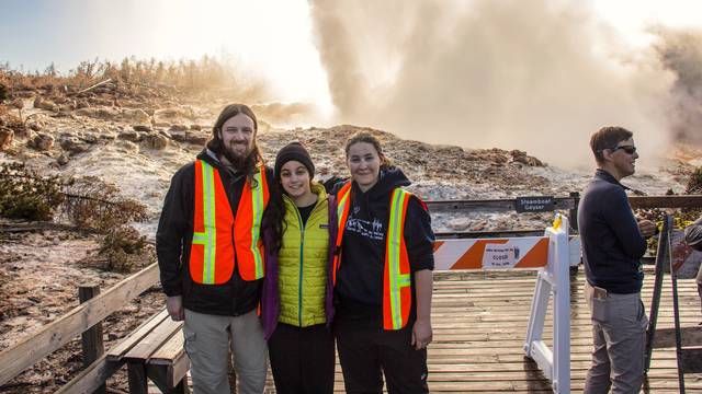 UW-Eau Claire grad Mara Reed (right) stands in front of Steamboat Geyser in Yellowstone National Park. Reed’s research about geyser’s more frequent eruptions is gaining national attention. (Photo by Carol Beverly)