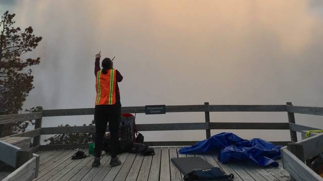 Blugold Mara Reed looks at the famous Steamboat Geyser as it begins a major eruption. (Photo by Xiaojing Ruby Fu)