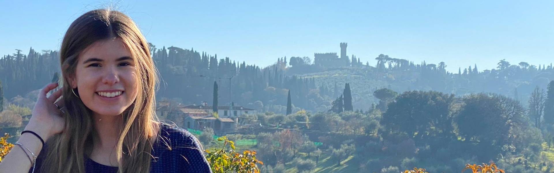 Fall 20 Library scholarship winner Audrey standing in front of a beautiful green landscape