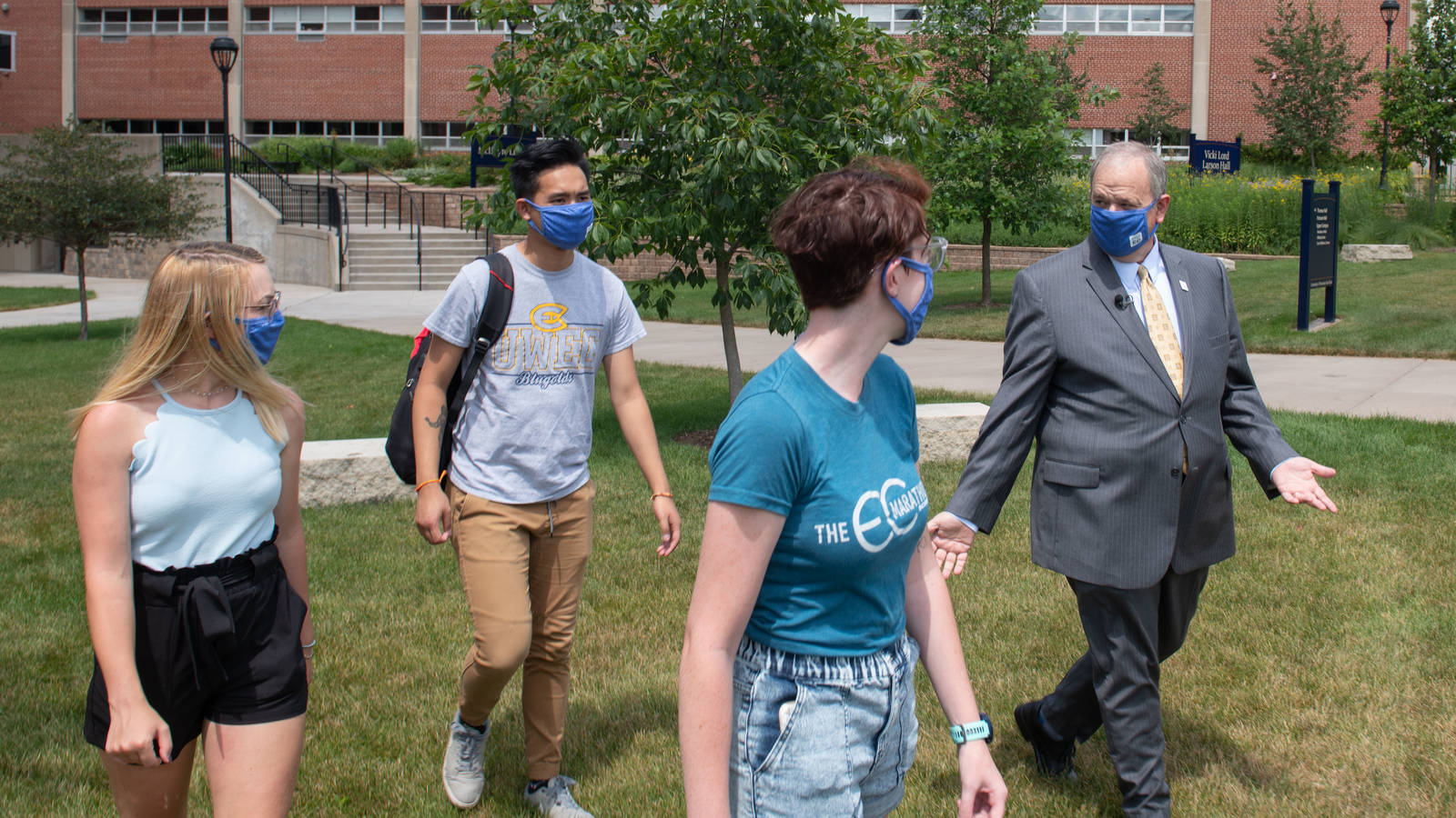 Chancellor Schmidt walks on campus with students pre-reopeing, waering masks