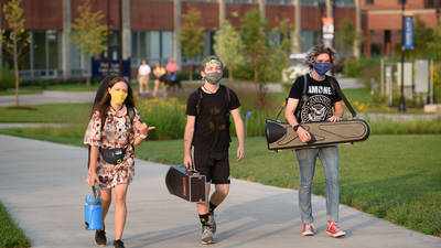 students carrying cased instruments outside