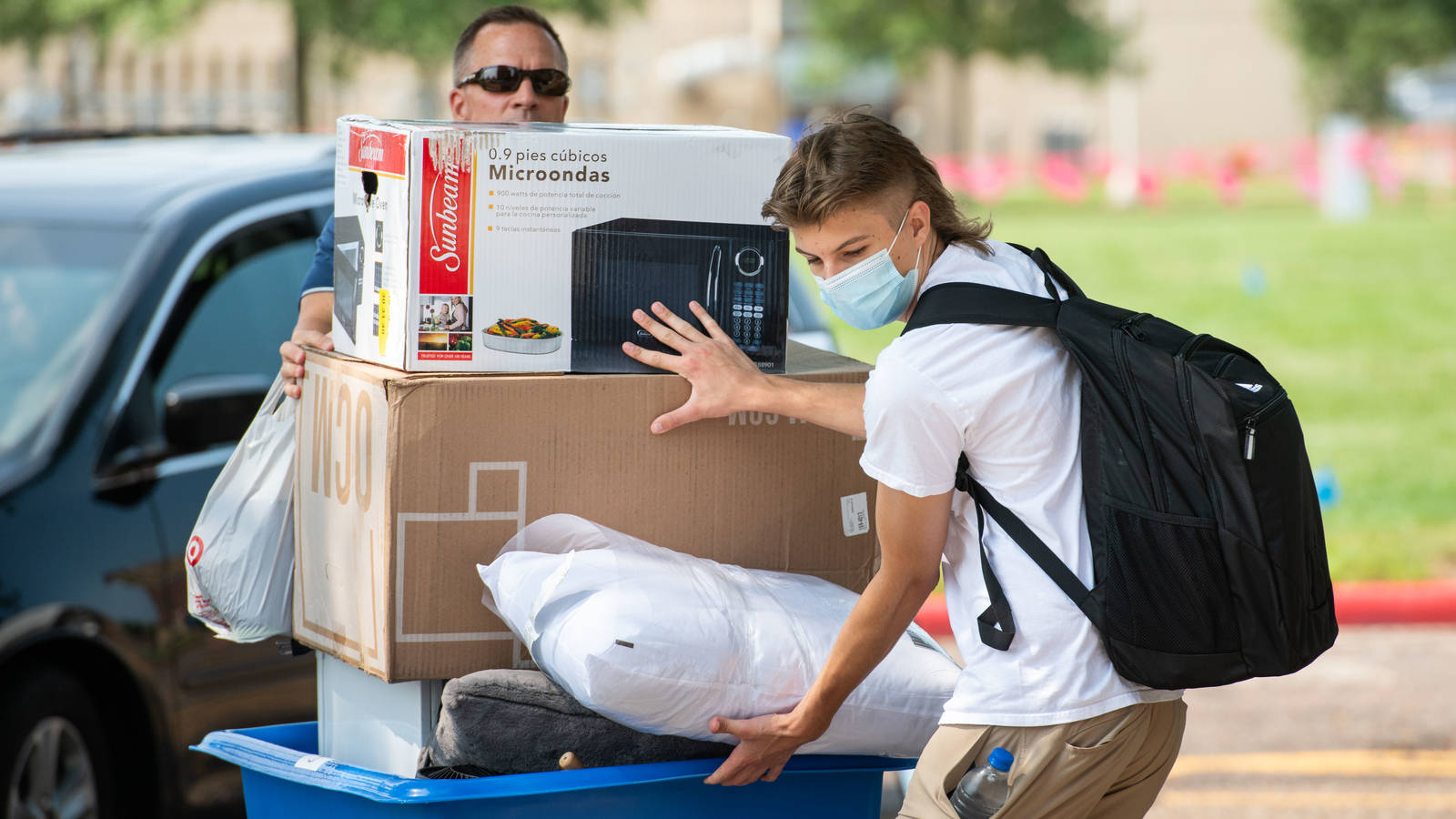 Students moving into dorms, masks on