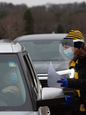 Antigen test site Blugold volunteer talking to driver