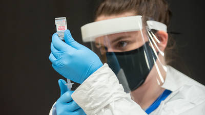 Student nurse loading vaccine syringe