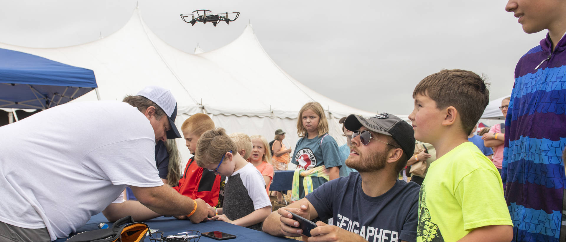 Kids and college student at toy drone table event