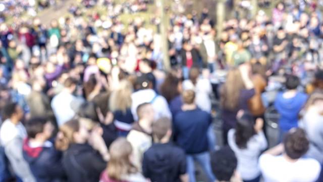 Blurred, defocused crowd protesting in public space