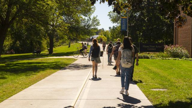 Students approaching footbridge near Haas Fine Arts Center