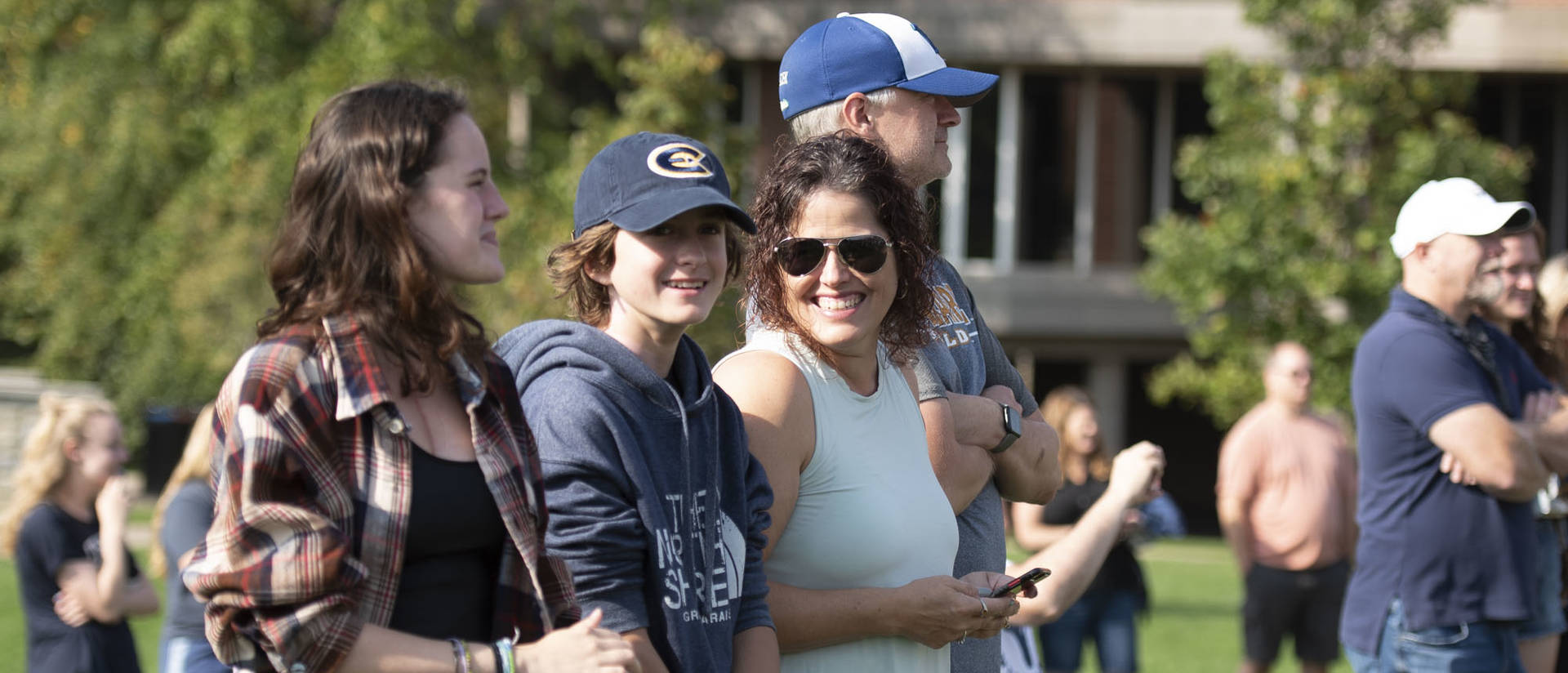 A smiling family outside during Family Weekend