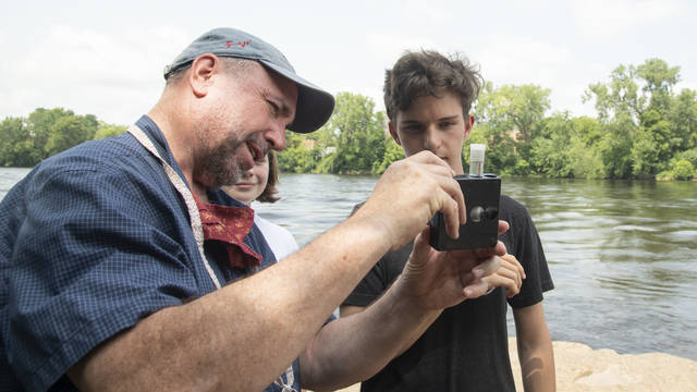 UW-Eau Claire geology professor Dr. J. Brian Mahoney shows high schooler Quinten Anger how to use a colorimetric kit to measure nitrate concentration in the Chippewa River. (Submitted photo)