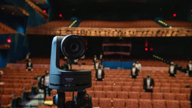 Photo of a camera in front of theatre seats