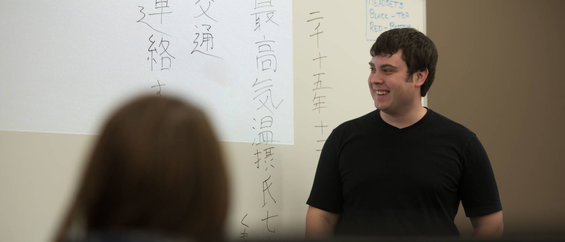 Students in a Japanese language class writing on white board