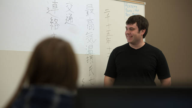 Students in a Japanese language class writing on white board