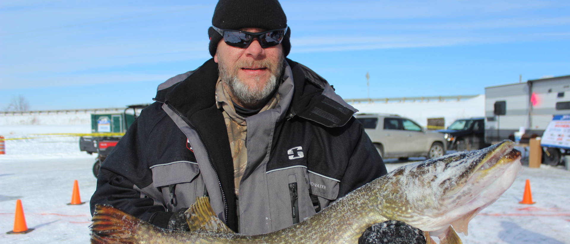 Ice fisherman holding a northern pike