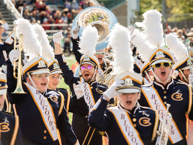 Blugold Marching Band members cheer at a football game