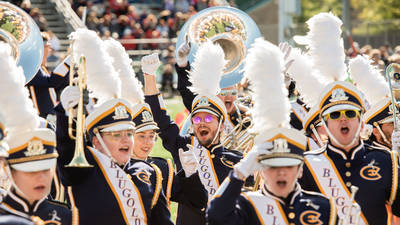 Blugold Marching Band members cheer at a football game