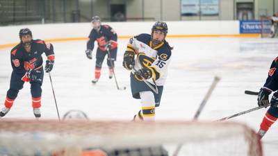 Women's hockey player shoots for a goal.