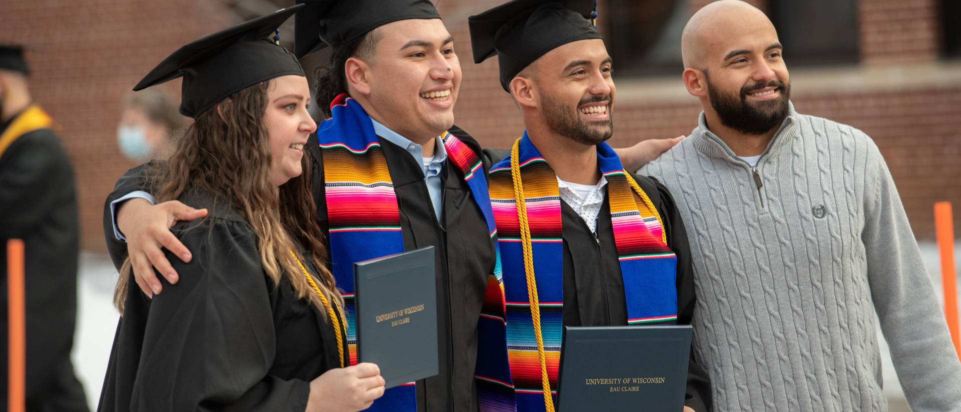 Commencement fall 2021, four students outside of Zorn Arena