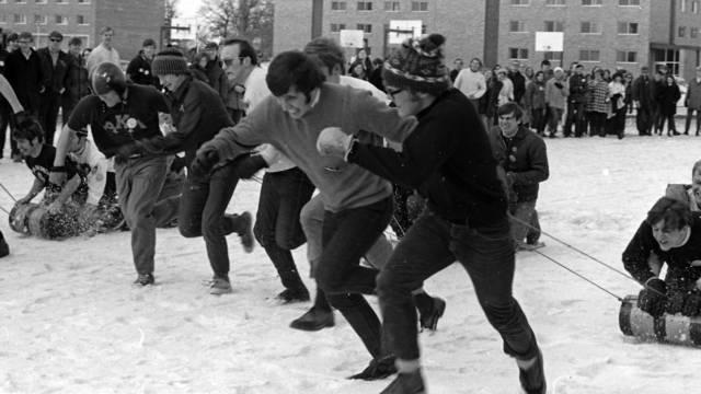 Male students competing in a sled race, ca. 1964-1971