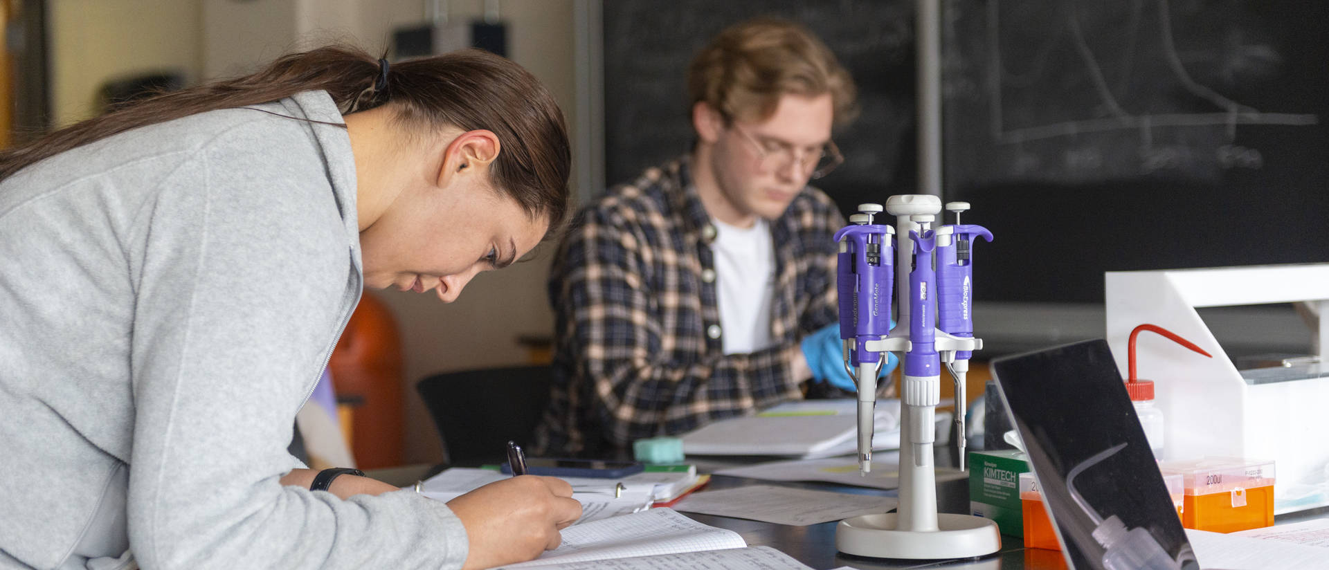 Biochemistry students conduct an experiment in a science lab on campus.