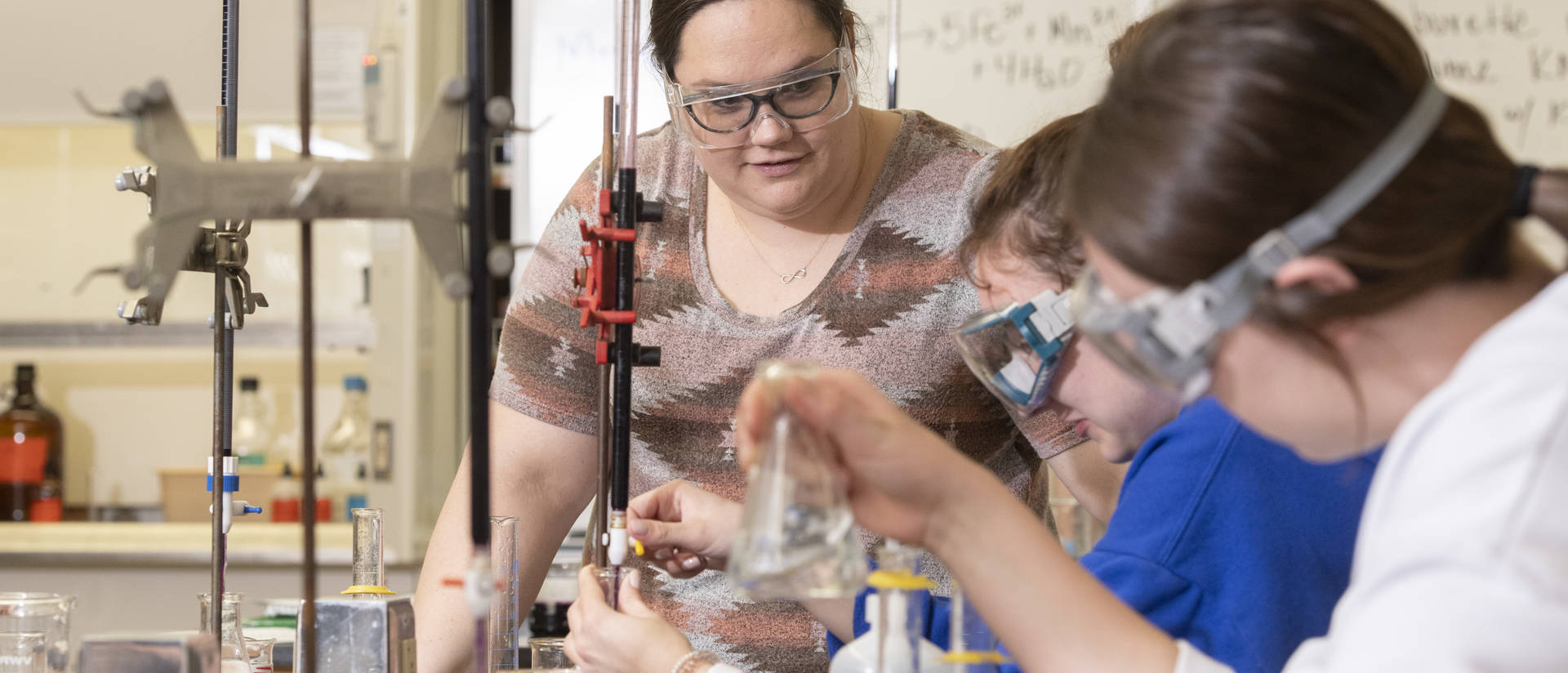 Students work on a chemistry experiment in a lab on campus.