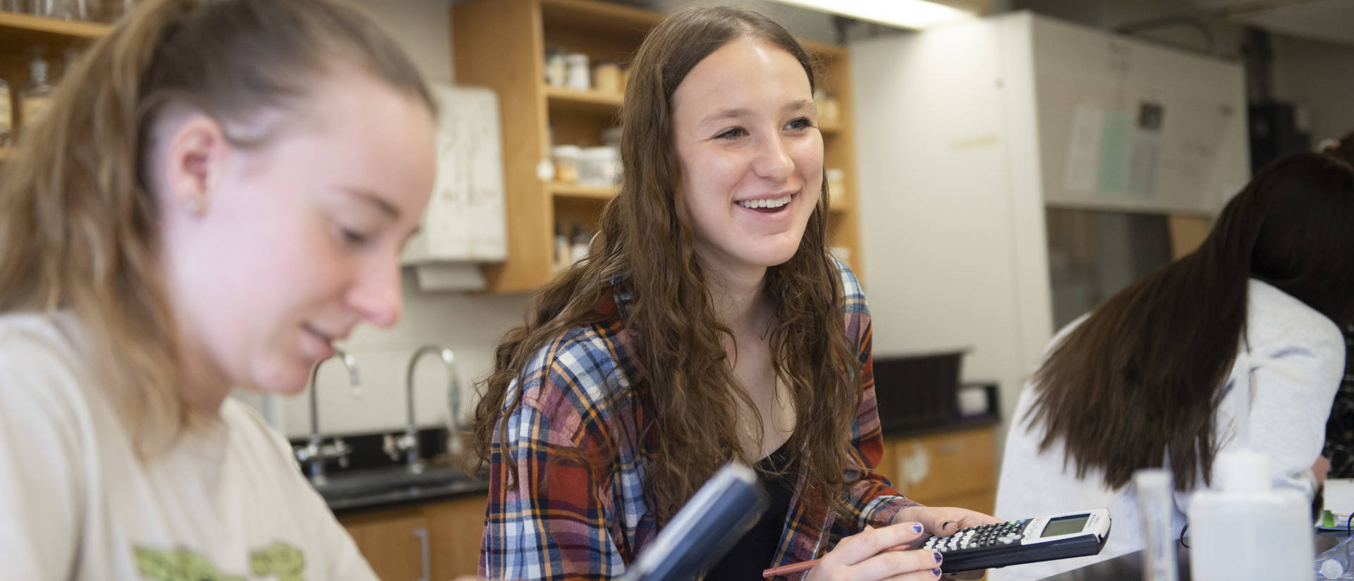 Chemistry students use calculators during a lab in class.