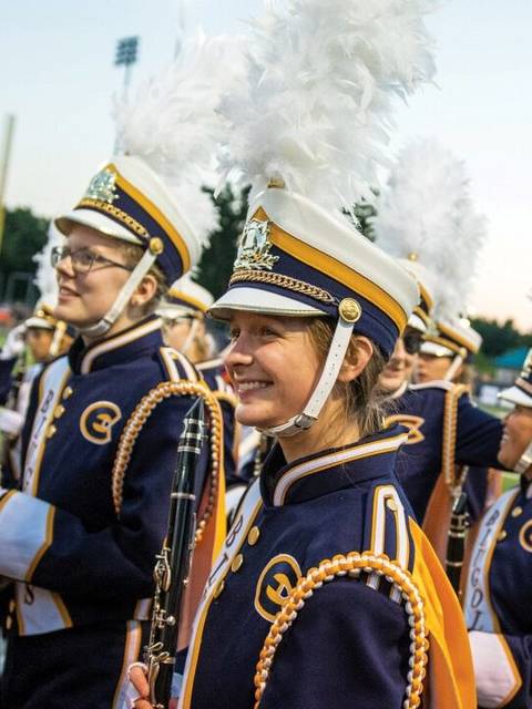 Blugold Marching Band members smile while in uniform at a performance