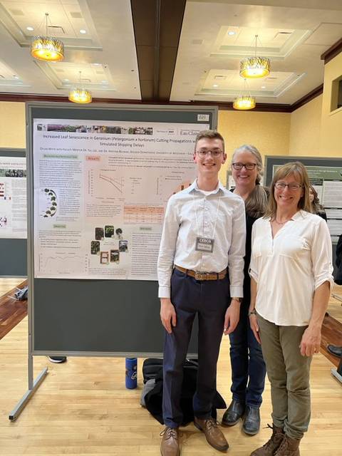 Blugolds pose with their poster at a research presentation