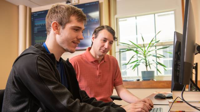 LTS staff and student collaborating at a computer station