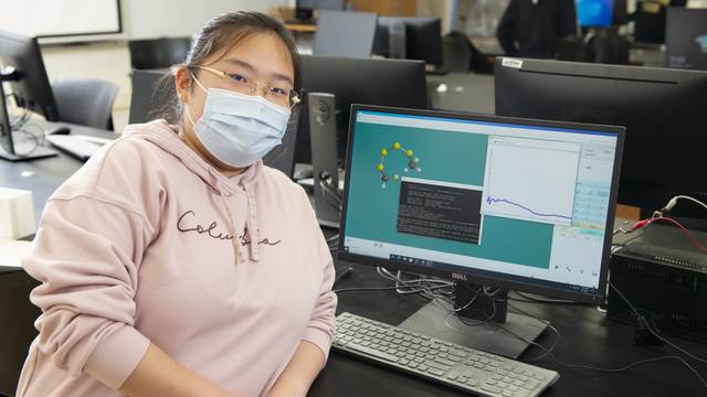 Ziyan Yang poses with a demonstration of her computational research into better battery materials.