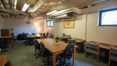 A study area in Oak Ridge Hall with multiple tables and chairs, string lights on the ceiling, and beanbag chairs