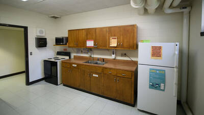 A kitchen with a fridge, oven, sink, microwave, and counter space.