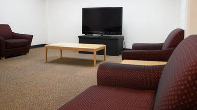Common space in Bridgman Hall with couches and a TV.