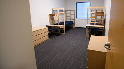 A room with two beds, desks and dressers