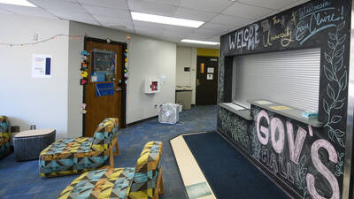 Lobby area of Governors Hall with colorful chairs and a welcome desk surrounded by a chalkboard wall decorated with a "Welcome to UWEC" message.